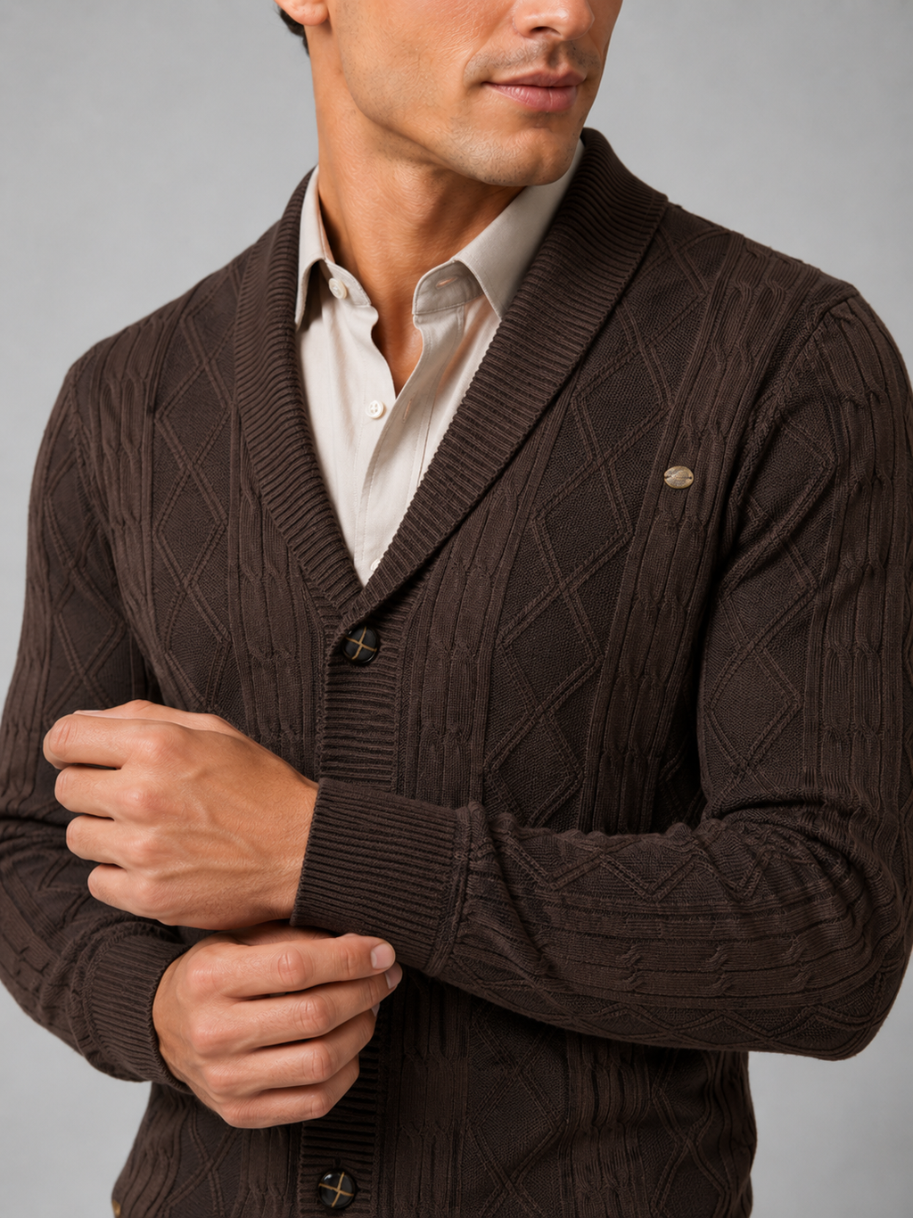 Close up of brown argyle cardigan showing cable knit texture and refined button front detail