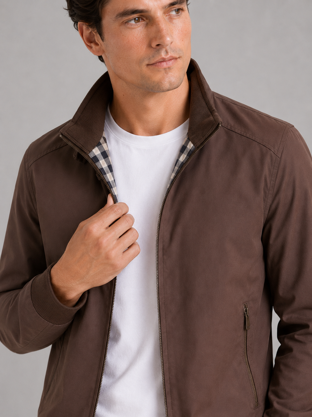 Close up of brown bomber jacket showing smooth fabric and refined zipper collar detail