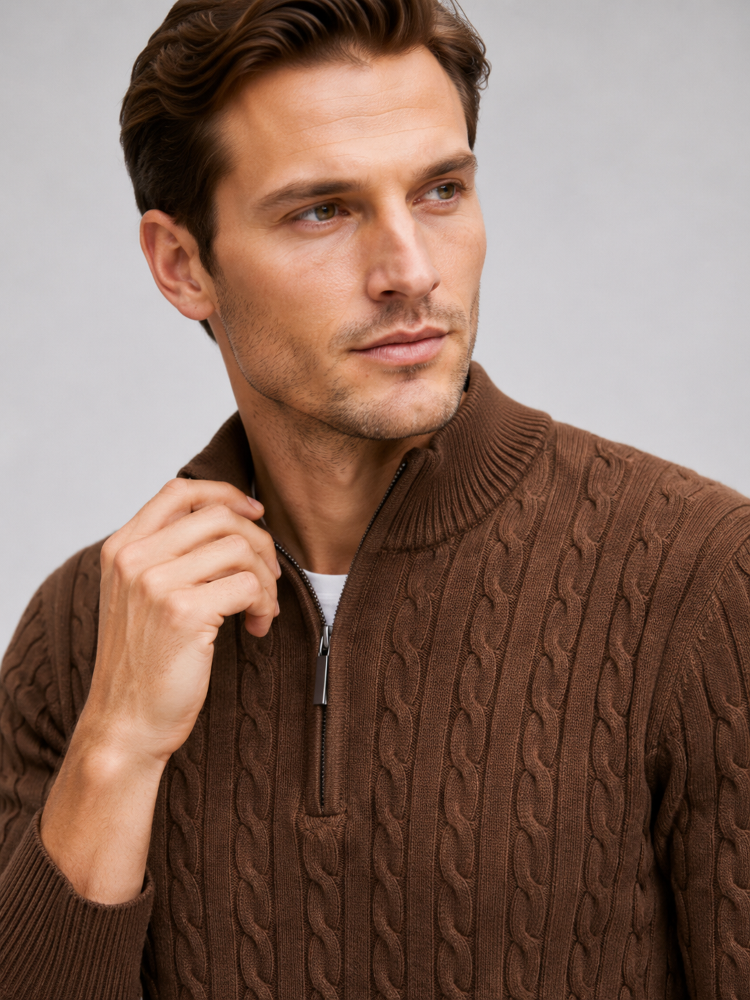 Close up of brown cable knit sweater showing textured pattern, mock neck, and quarter zip detail