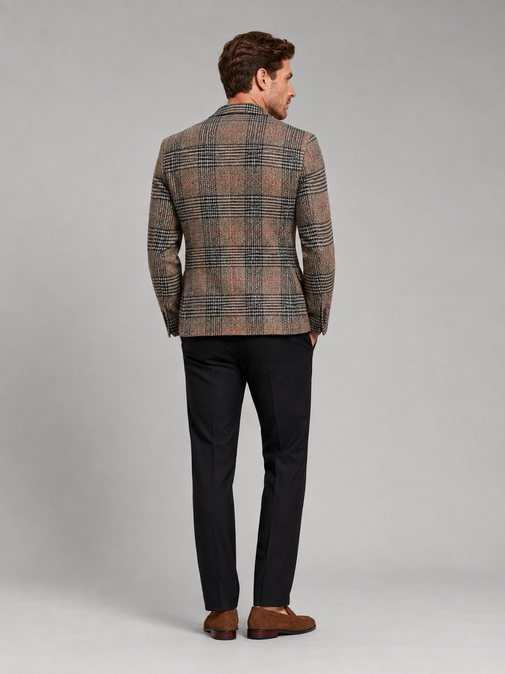Back view of a man wearing a brown checkered blazer showing the tailored slim fit, structured shoulders, and clean back design