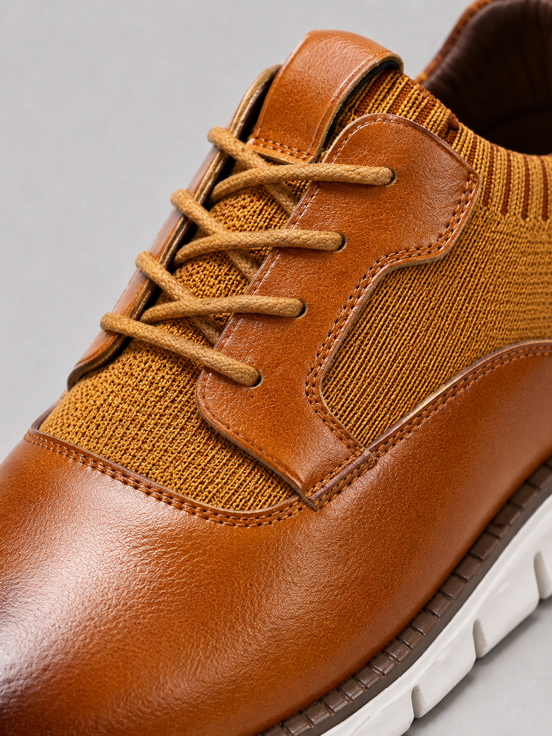 Close up of brown dress shoes showing smooth leather texture and secure lace up detail
