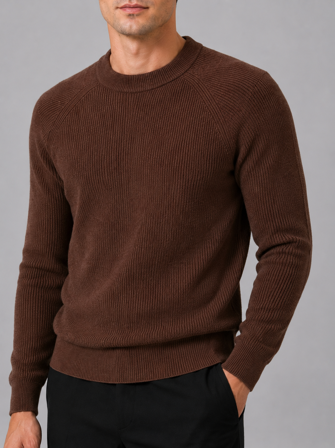 Close up of brown knit sweater showing thick soft fabric and classic crew neck detail