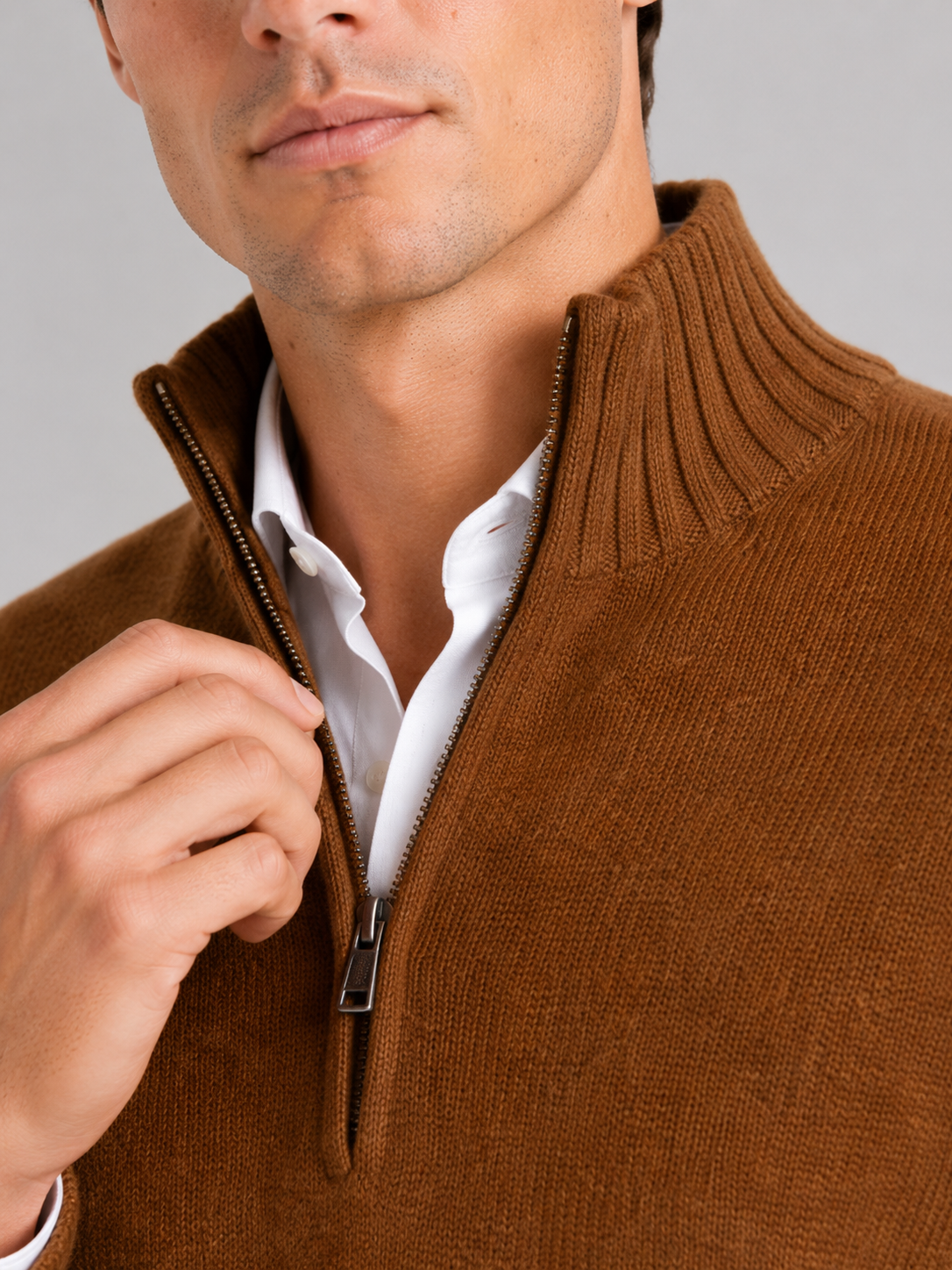 Close up of brown half zip sweater showing soft knit texture and refined zipper detail