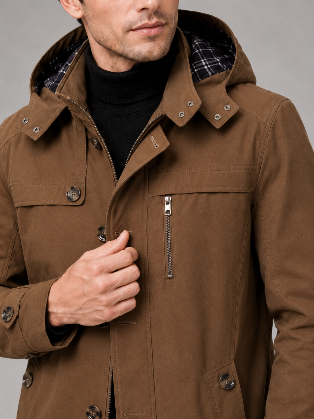 Close up of brown hooded trench coat showing thick cotton fabric, attached hood, and button front detail