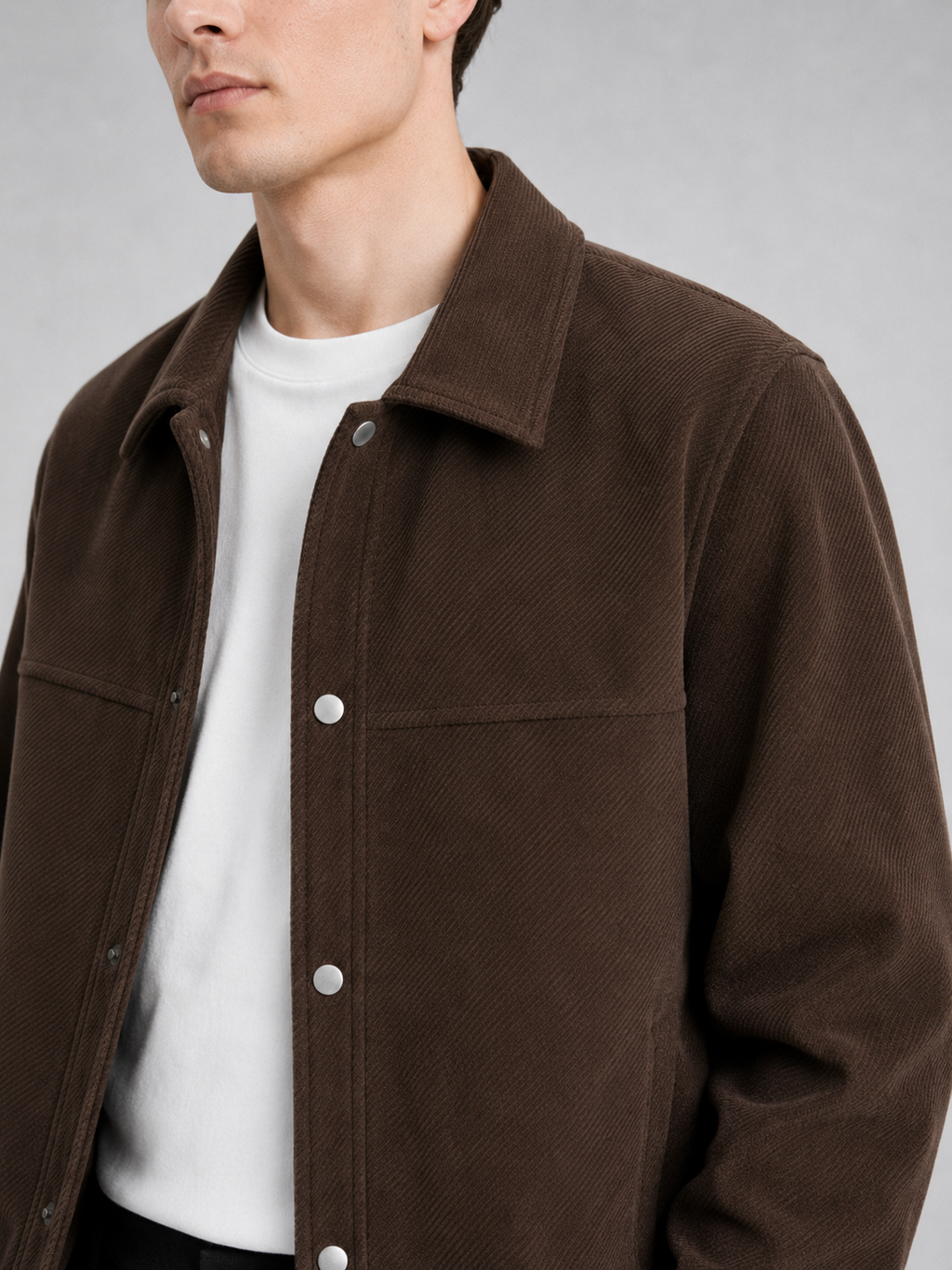 Close up of brown corduroy jacket showing soft ribbed texture, classic lapel, and button front detail