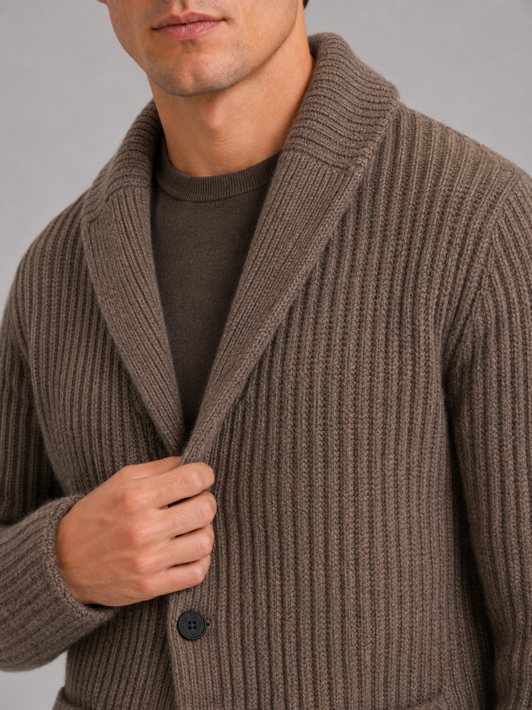 Close up of brown knit cardigan showing soft warm texture and refined lapel button detail