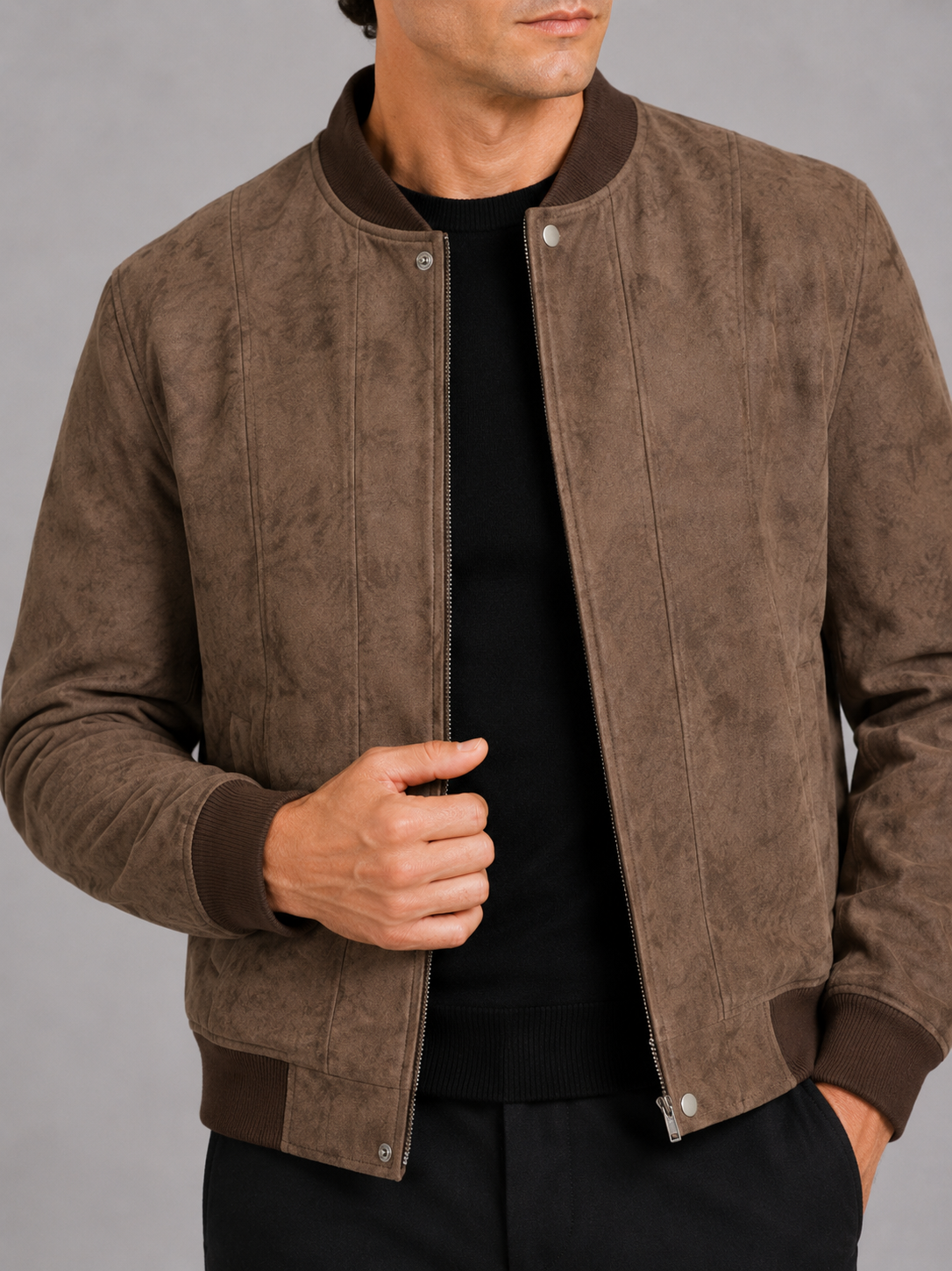 Close up of brown suede bomber jacket showing soft suede texture and stand collar zipper detail