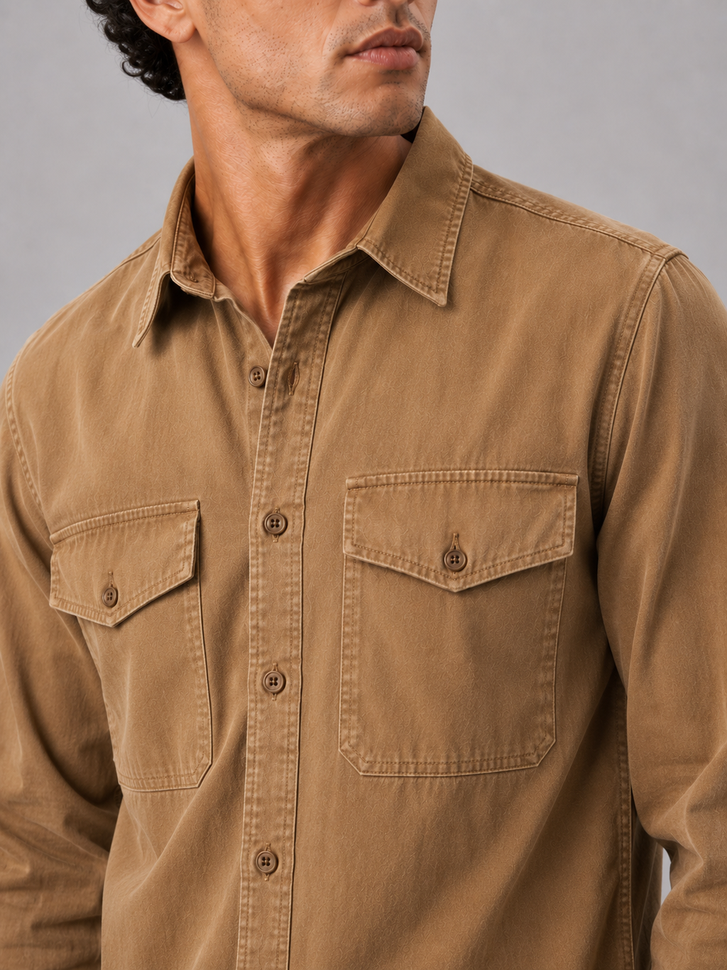 Close up of brown washed cotton work shirt showing soft fabric texture and pocket detail