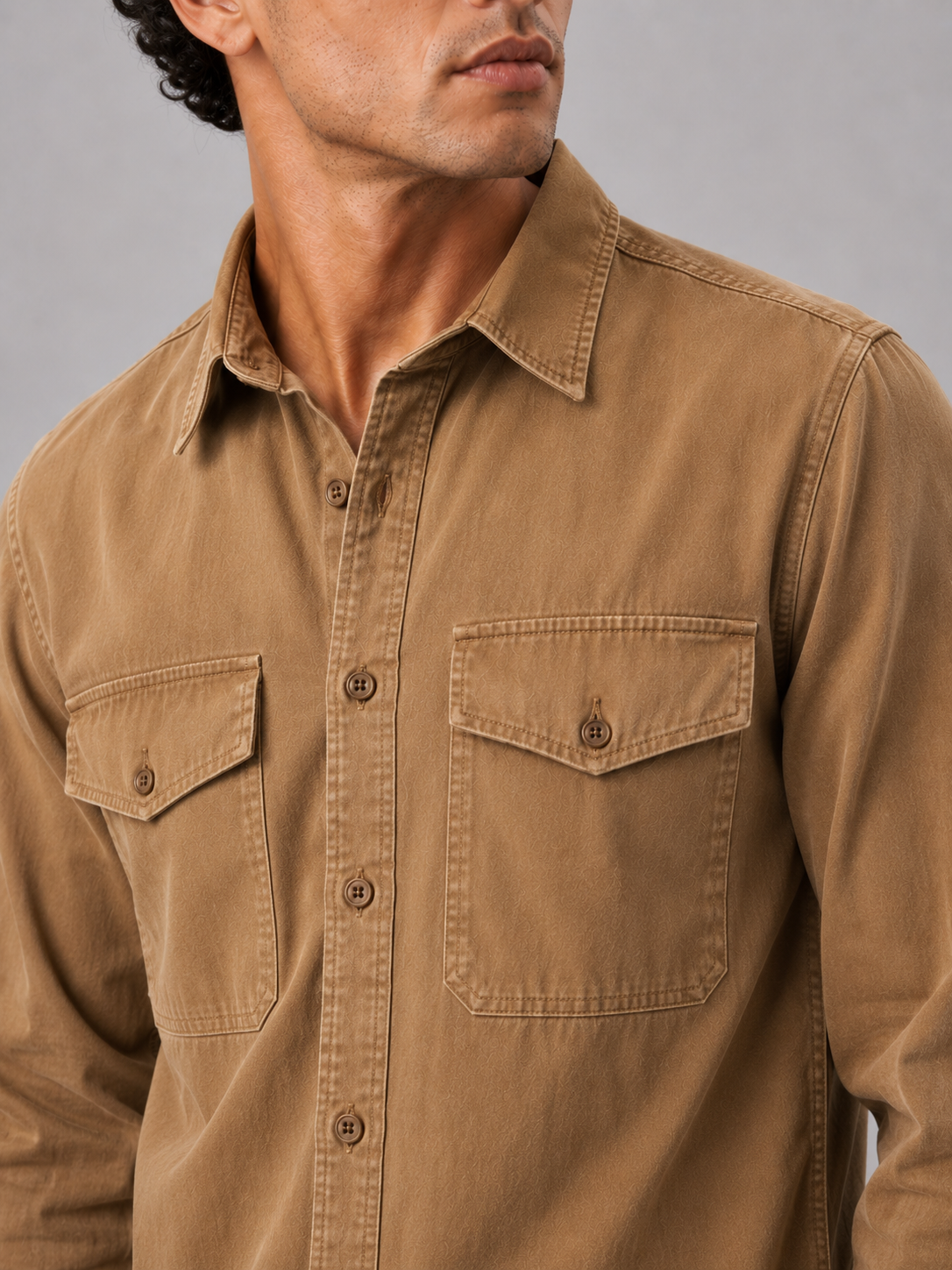 Close up of brown washed cotton work shirt showing soft fabric texture and pocket detail