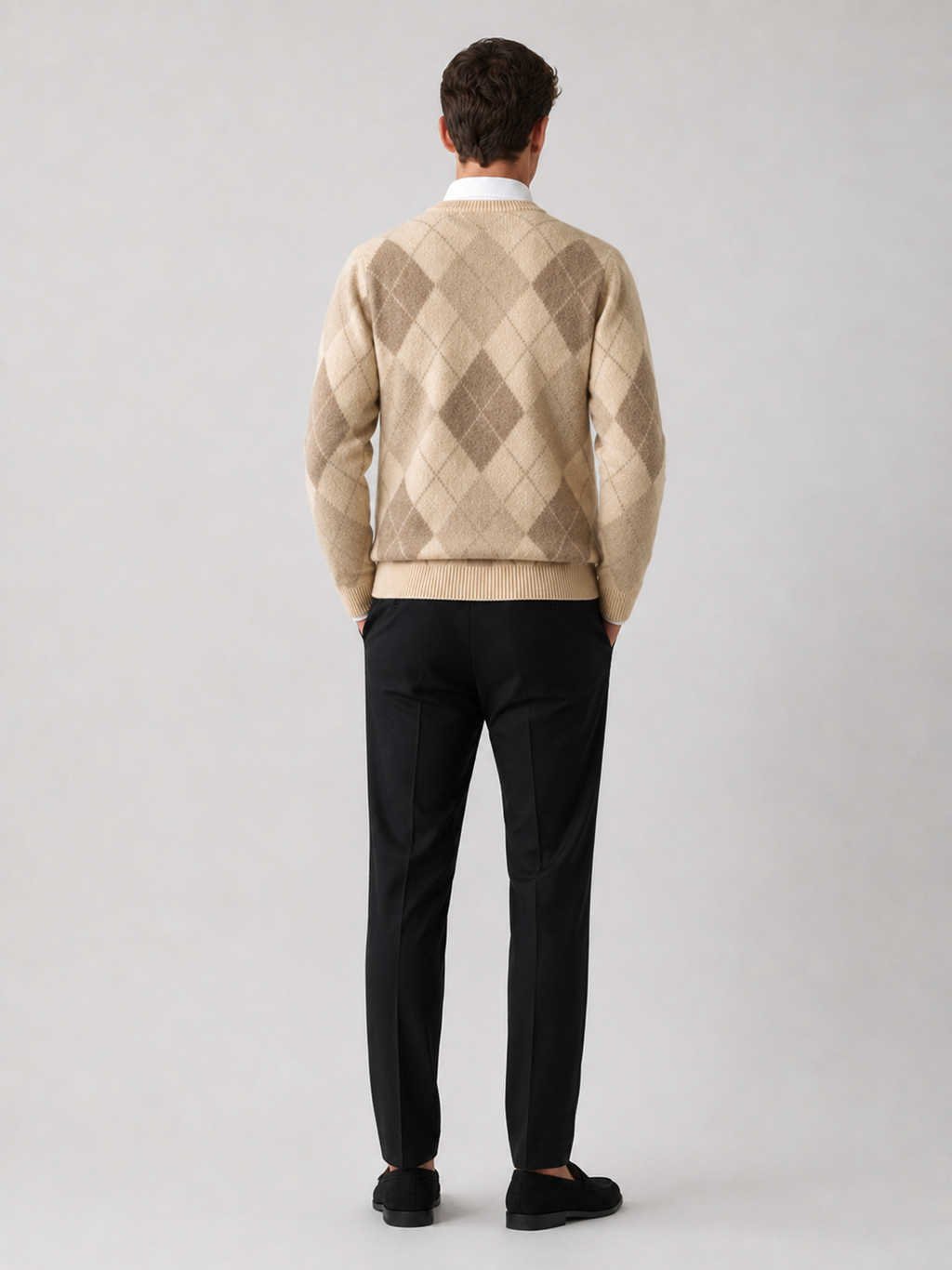 Back view of a man wearing a brown wool argyle sweater showing the crew neck, long sleeves, thick knit fabric, and comfortable fit