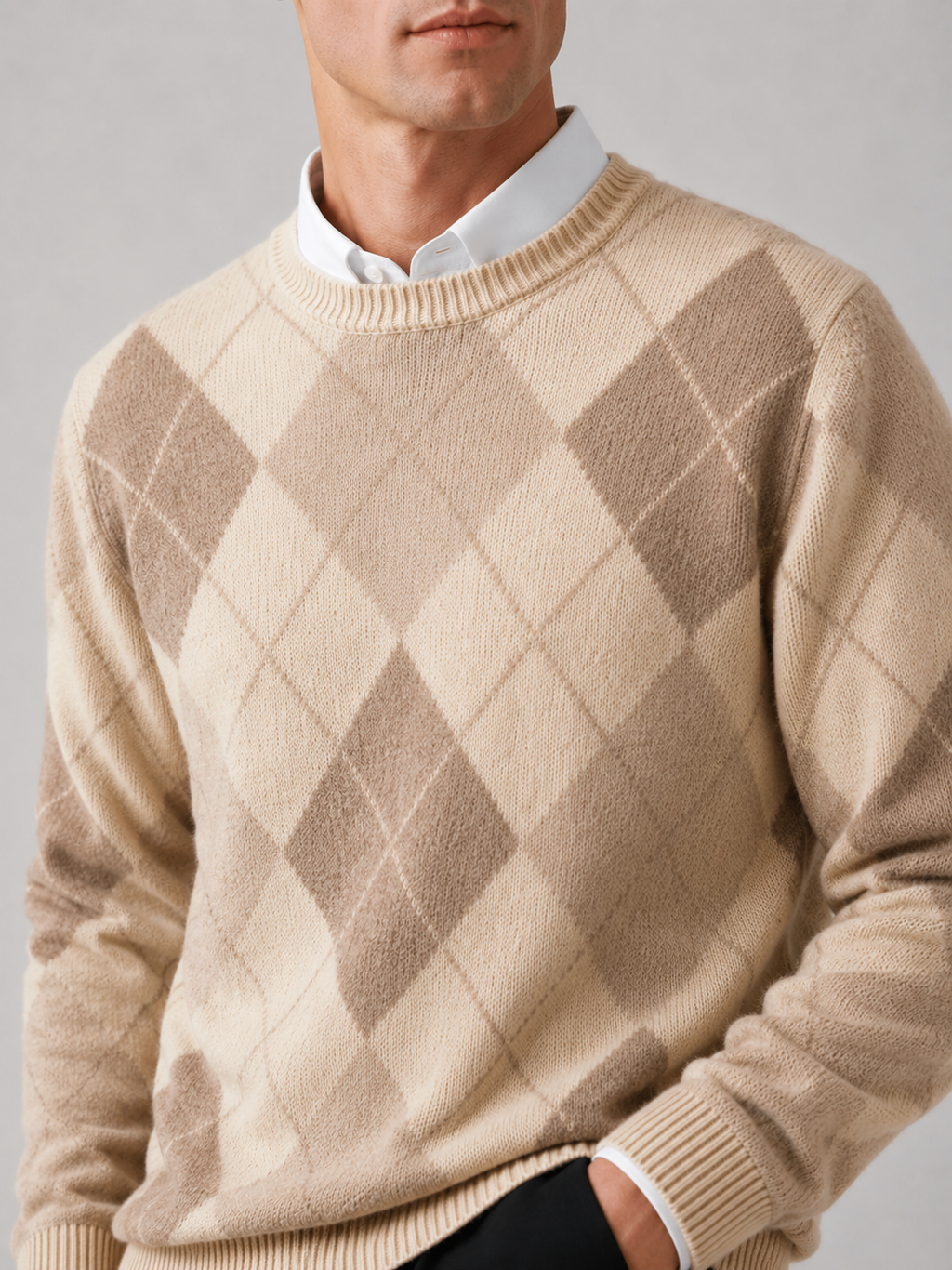 Close-up of a brown wool argyle sweater showing the diamond pattern, thick knit texture, crew neckline, ribbed cuffs, and hem