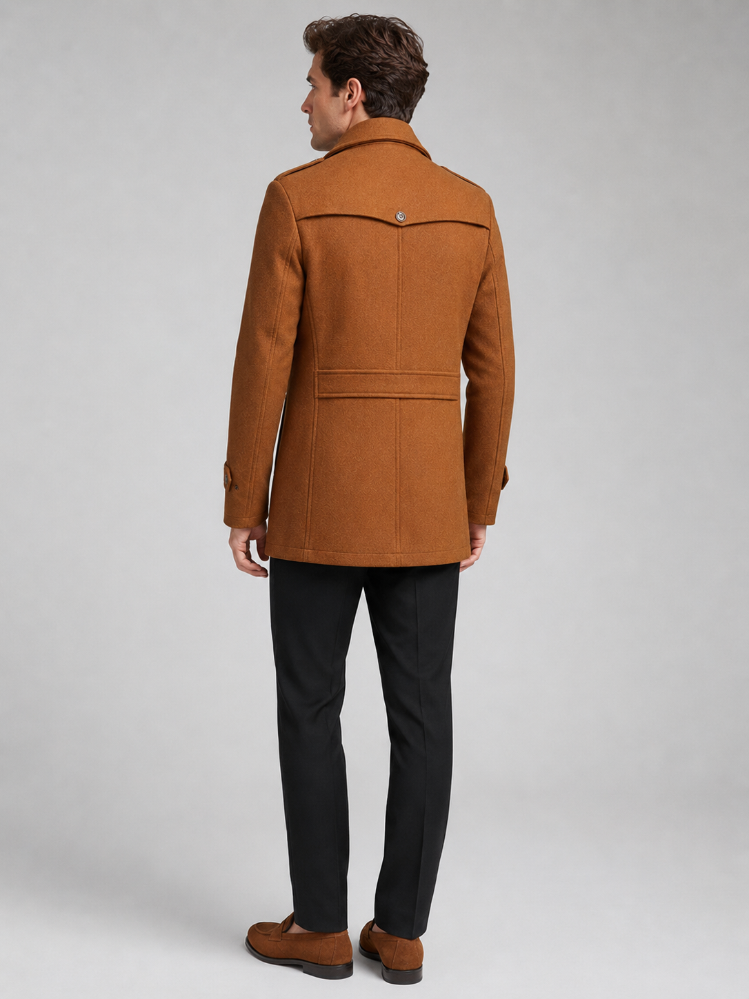 Back view of a man wearing a brown wool coat showing the structured shoulders, long silhouette, and tailored fit