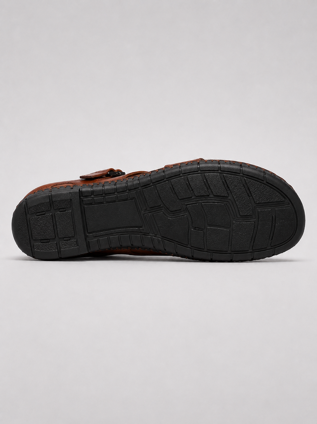 Brown leather sandals in a relaxed summer beach and casual outdoor outfit