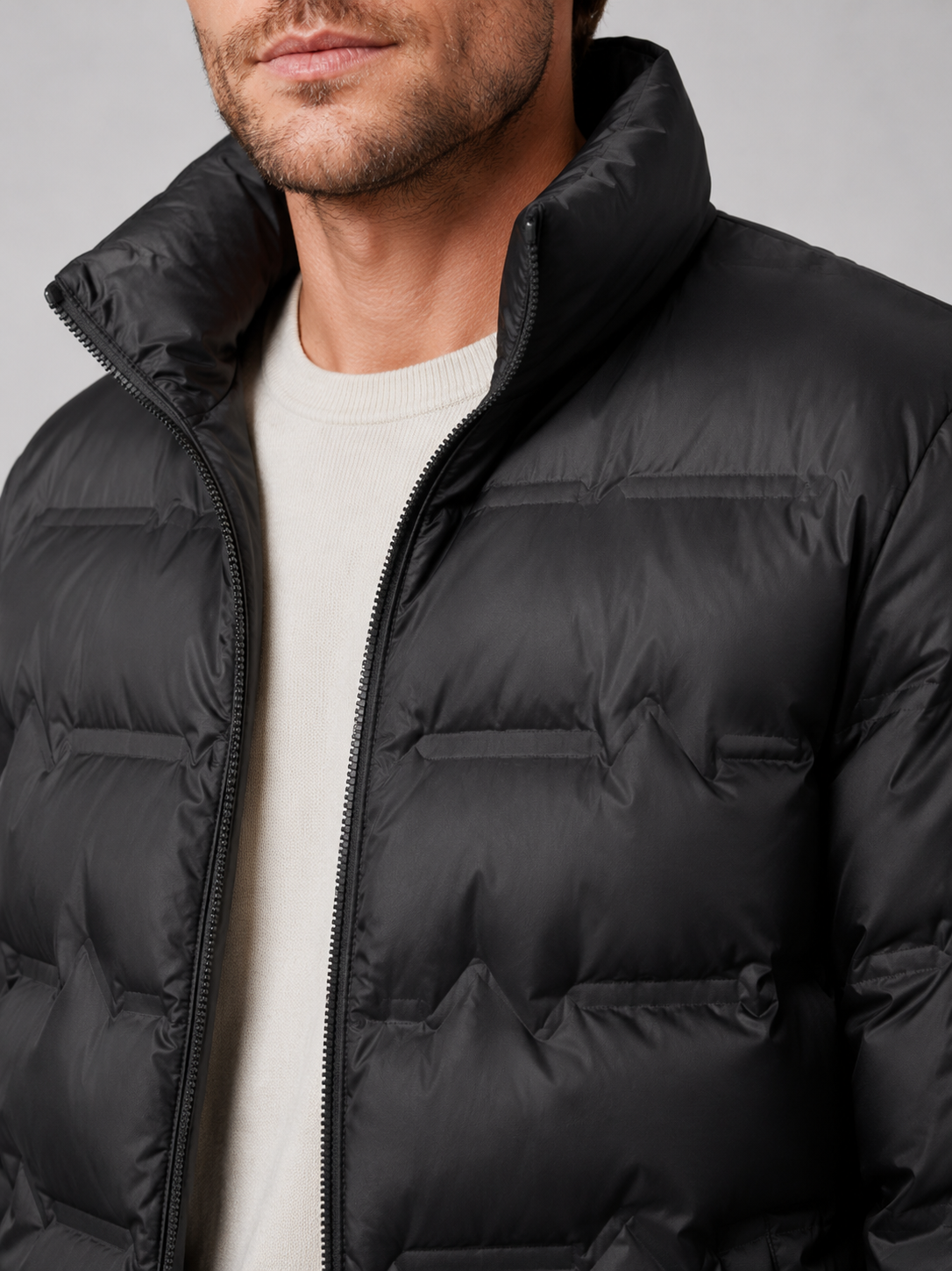 Close up of black white duck down jacket showing premium quilted insulation, stand collar, and weather resistant fabric detail