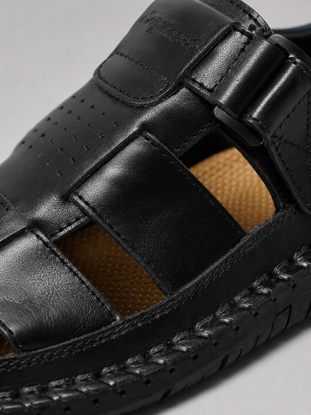 Close up of black leather sandals showing comfortable cushioned sole and premium strap stitching