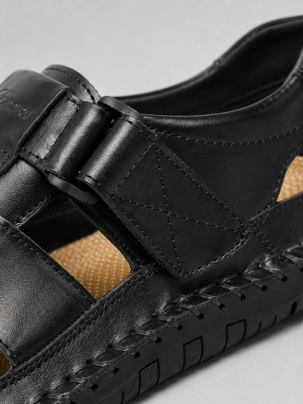Close up of black leather sandals showing soft leather texture and adjustable strap detail