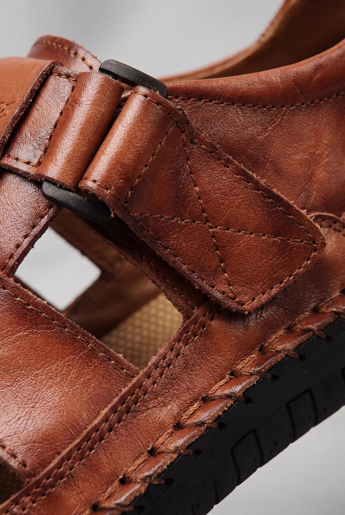 Close up of brown leather sandals showing soft leather texture and adjustable strap detail