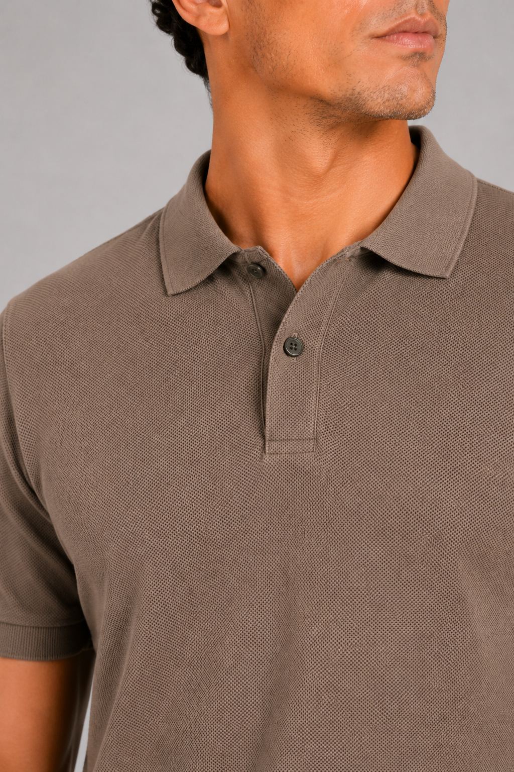 Close up of coffee polo shirt showing smooth silk touch fabric and refined collar detail
