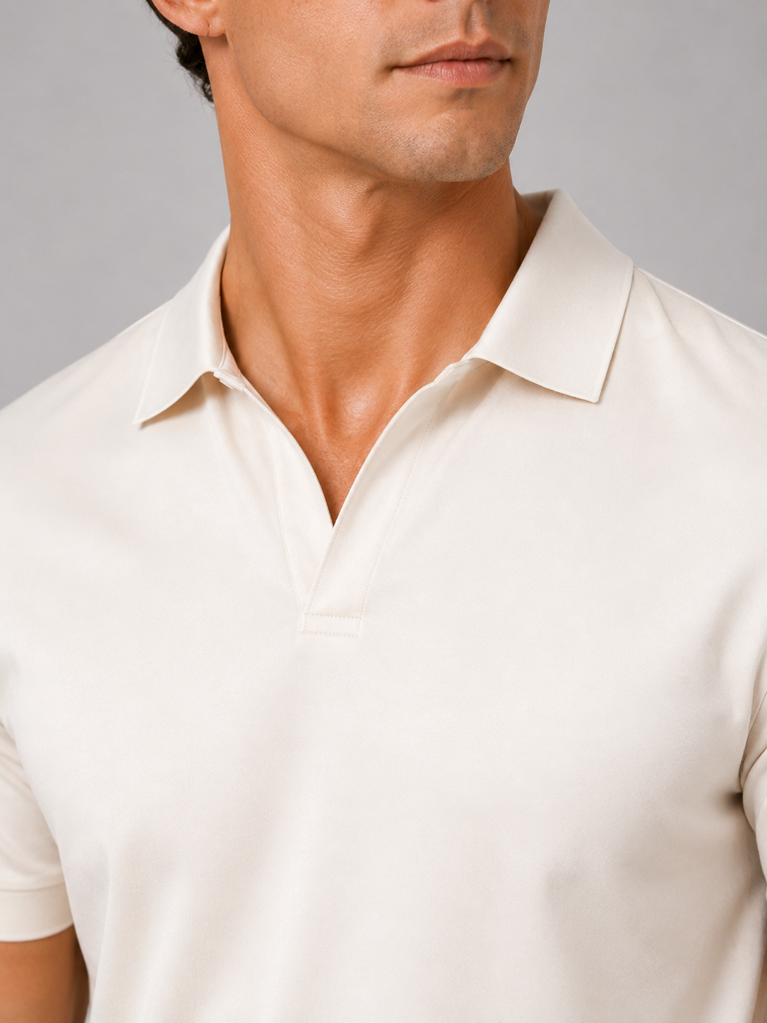 Close up of cream polo shirt showing smooth silky fabric and refined collar detail