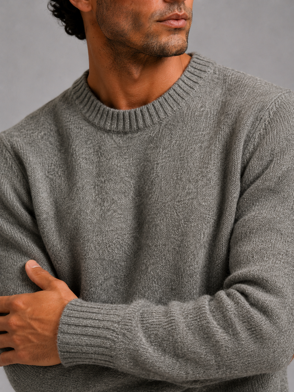 Close up of gray wool knit sweater showing thick warm texture and clean crew neck detail
