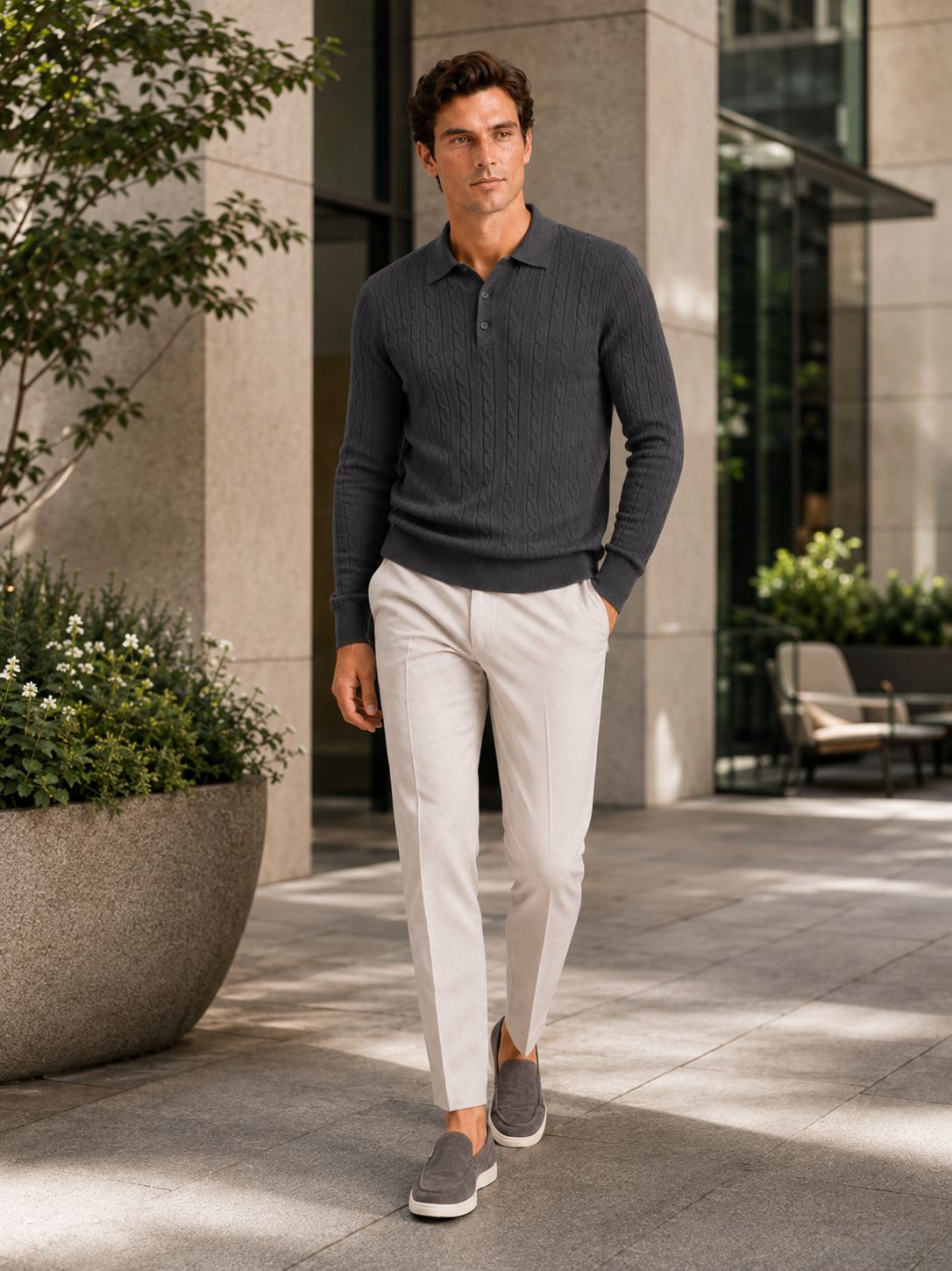 Man styling dark gray cable knit long sleeve polo in a clean winter lifestyle outfit