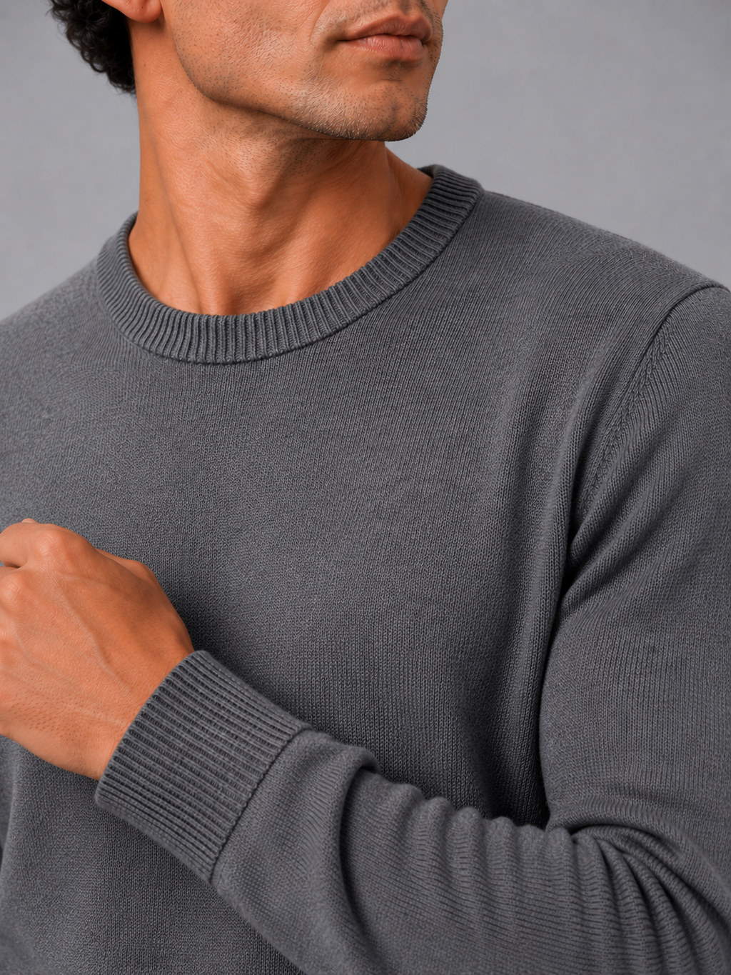 Close up of dark gray knit sweater showing soft lightweight fabric and clean crew neck detail