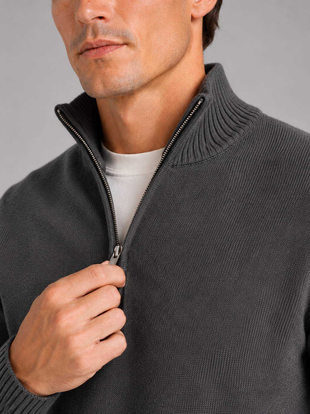Close up of dark gray half zip sweater showing soft knit texture and refined zipper detail