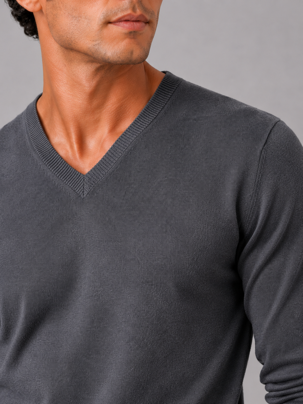 Close up of dark gray knit sweater showing soft lightweight fabric and refined v neck detail