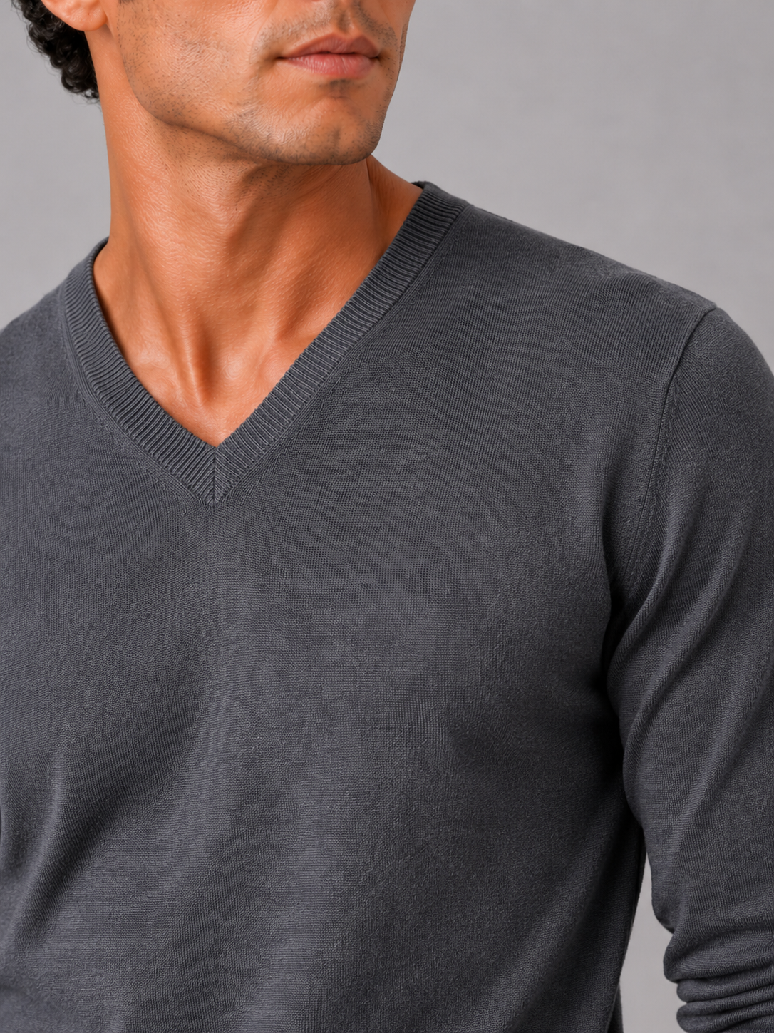 Close up of dark gray knit sweater showing soft lightweight fabric and refined v neck detail