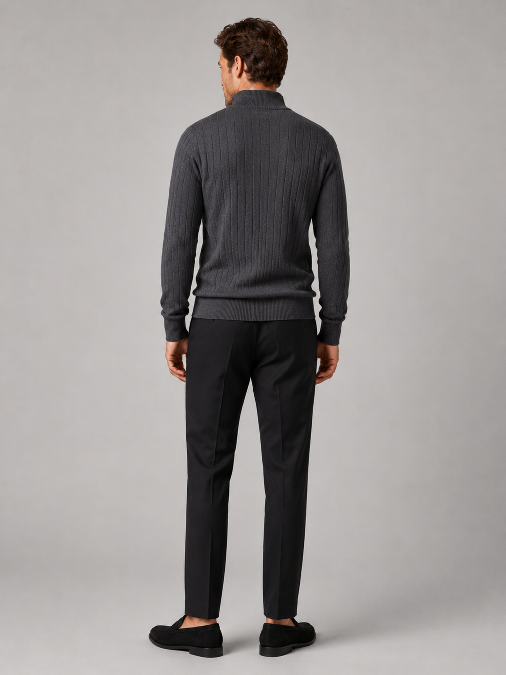 Back view of a man wearing a dark gray quarter zip sweater showing the long sleeves, clean knit construction, and comfortable fit