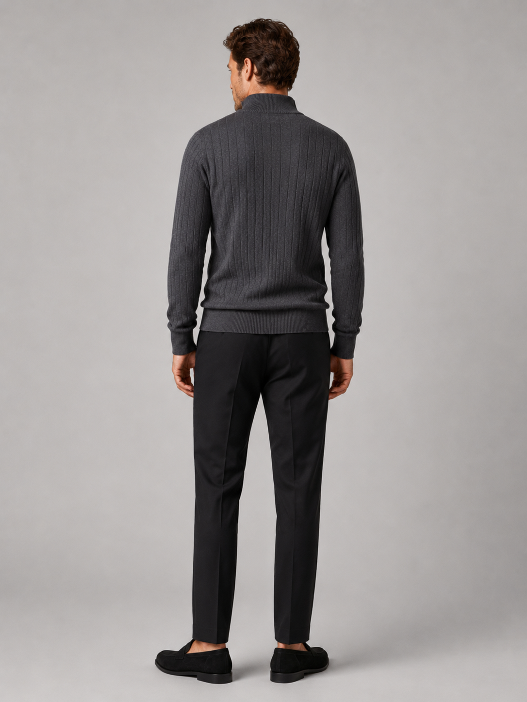 Back view of a man wearing a dark gray quarter zip sweater showing the long sleeves, clean knit construction, and comfortable fit