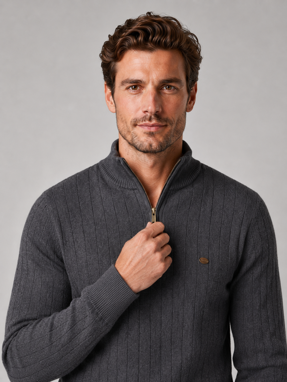 Close-up of a dark gray quarter zip pullover sweater showing the cotton knit texture, stand collar, zipper placket, cuffs, hem, and stitching details