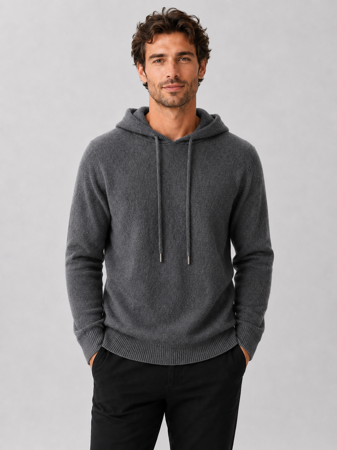 Front view of a man wearing a dark gray wool hoodie sweater with a soft knit design, attached hood, and long sleeves