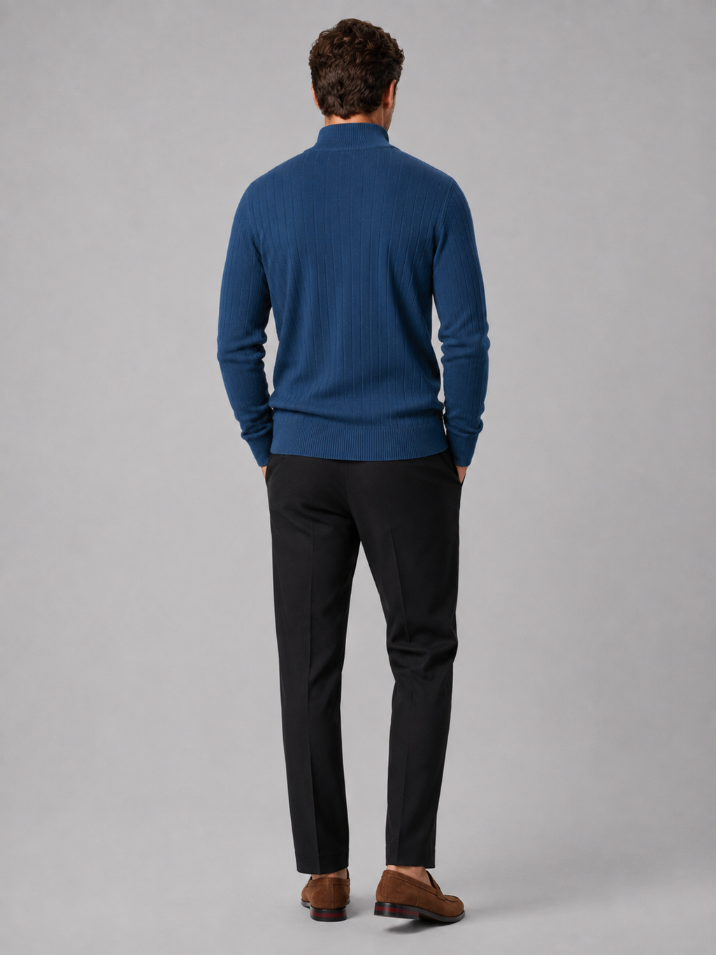 Back view of a man wearing a denim blue quarter zip sweater showing the long sleeves, clean knit construction, and comfortable fit