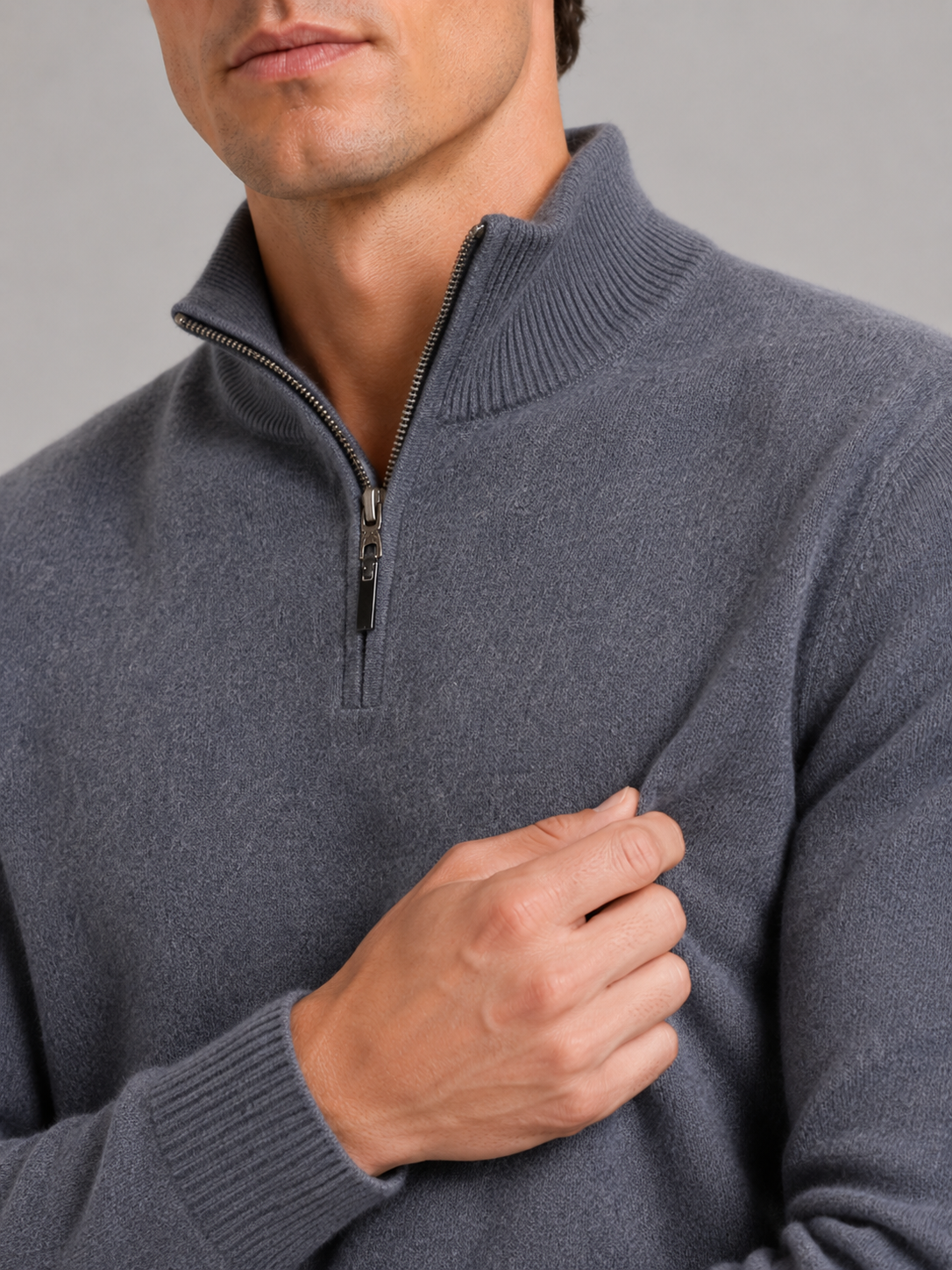 Close up of gray wool half zip sweater showing thick knit texture and refined zipper detail