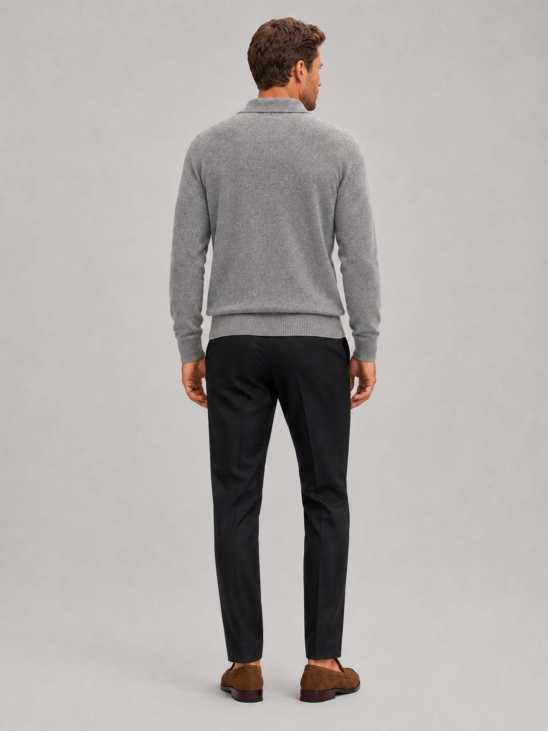 Back view of a man wearing a gray argyle sweater showing the solid knit back, long sleeves, and comfortable fit