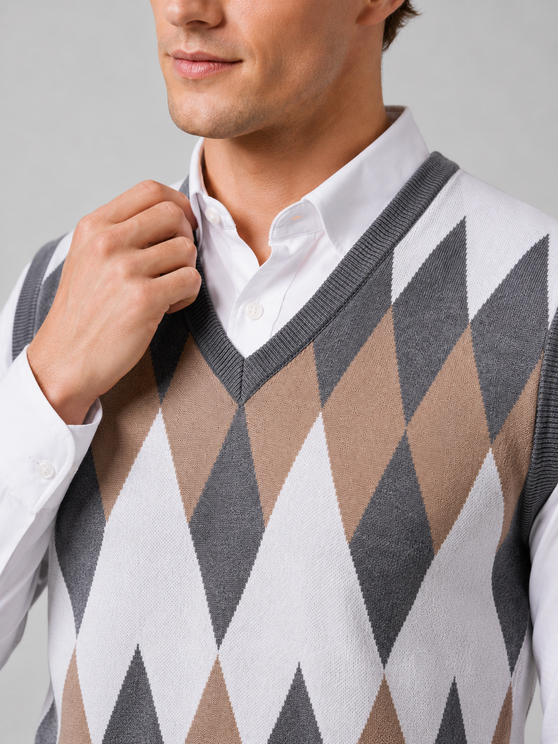 Close up of gray argyle sweater vest showing classic diamond knit pattern and refined v neck detail