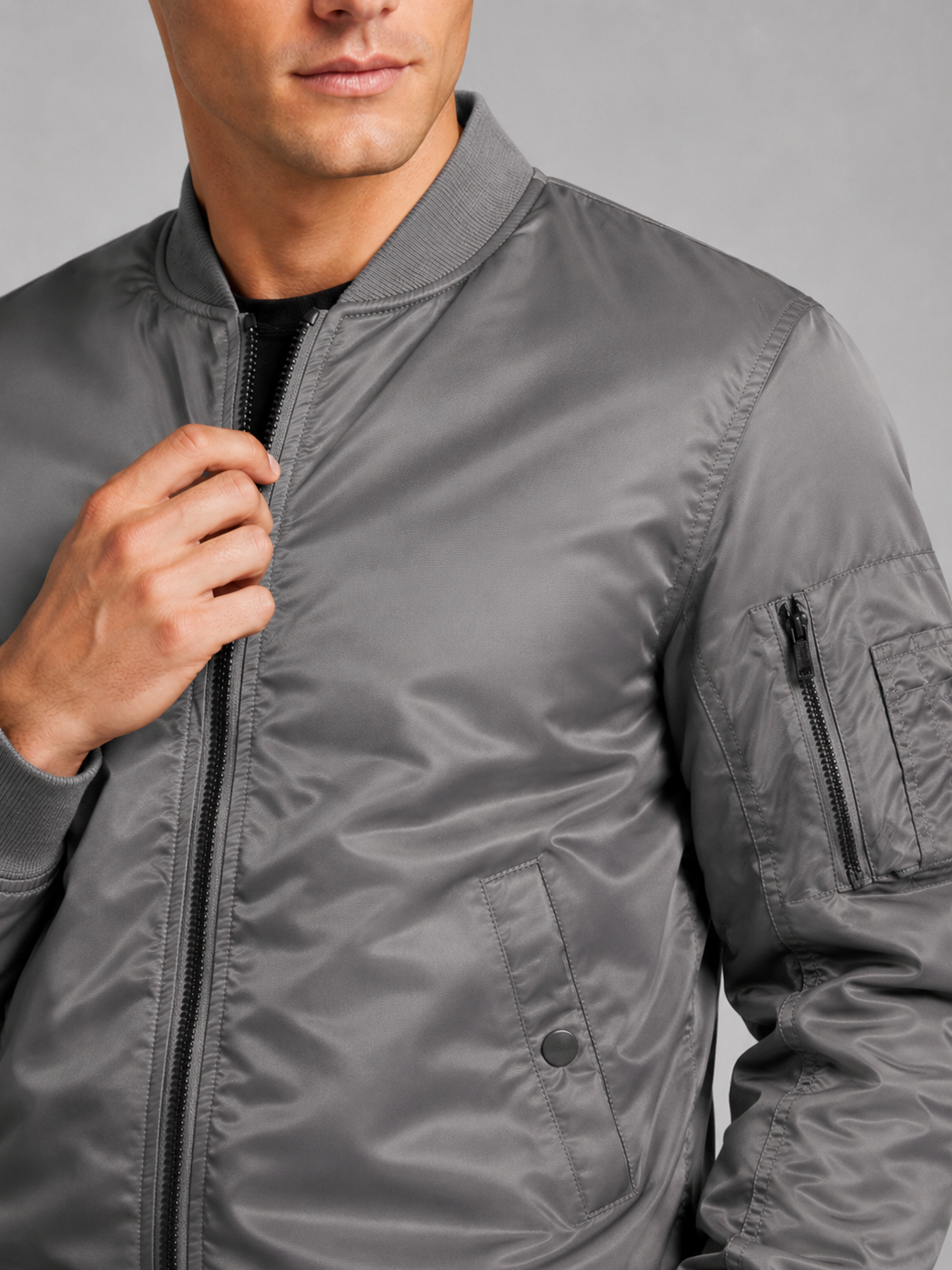 Close up of gray bomber jacket showing lightweight windbreaker fabric and zip up front detail