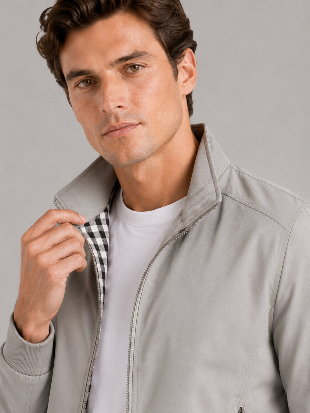 Close up of gray bomber jacket showing smooth fabric and refined zipper collar detail