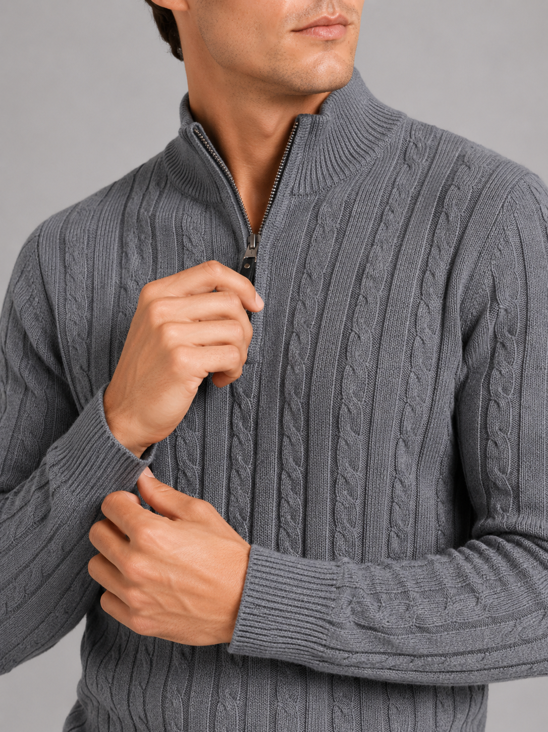 Close up of gray cable knit sweater showing thick textured fabric and quarter zip detail