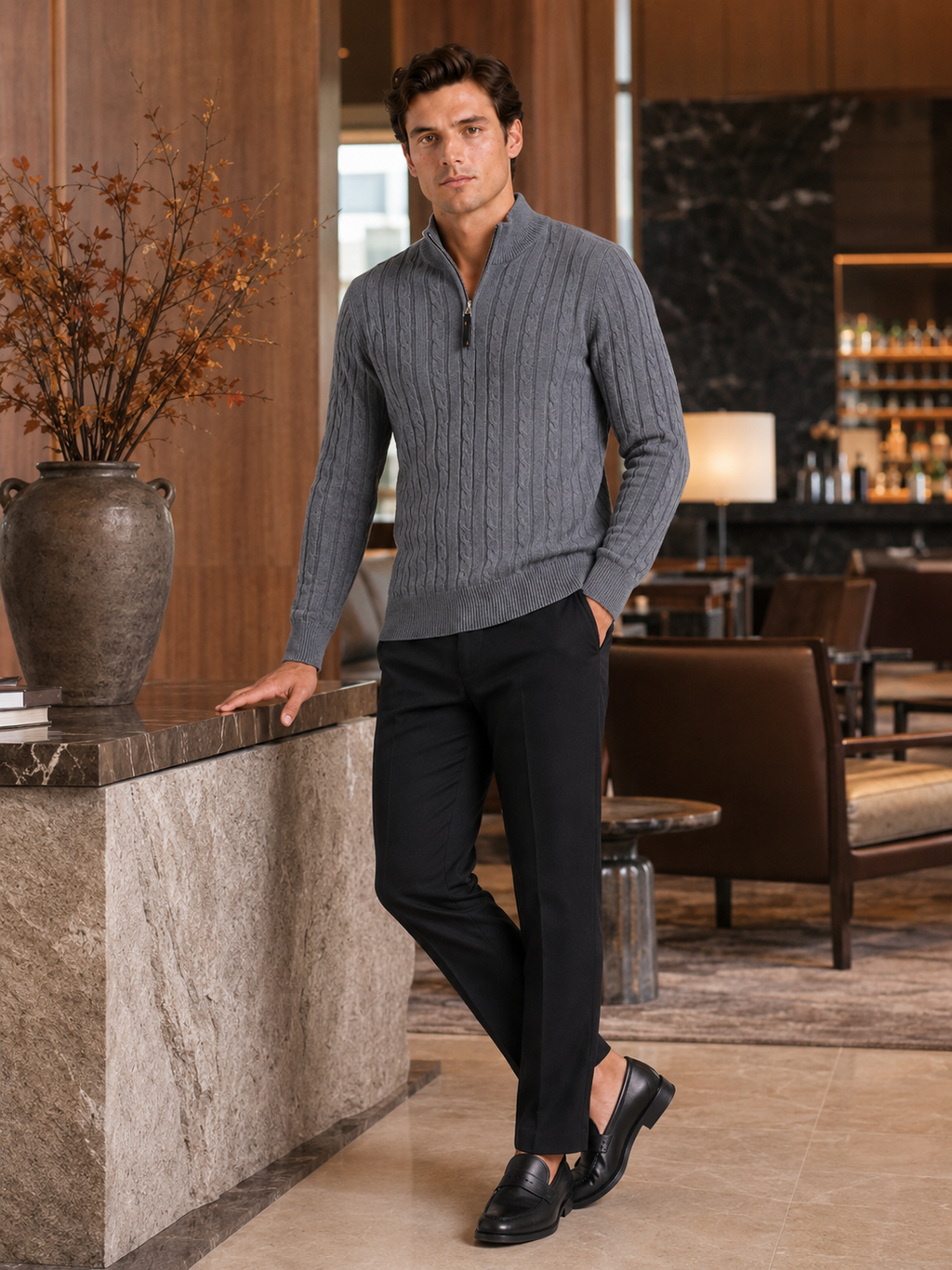 Man styling gray cable knit quarter zip sweater in a clean fall winter lifestyle outfit