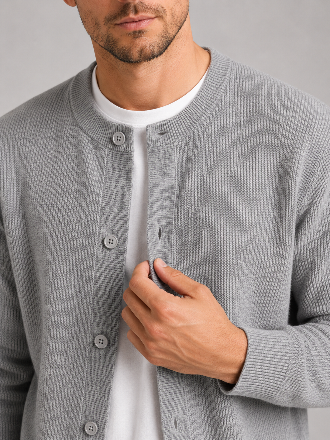 Close up of gray knit cardigan showing soft textured fabric and classic crew neck detail