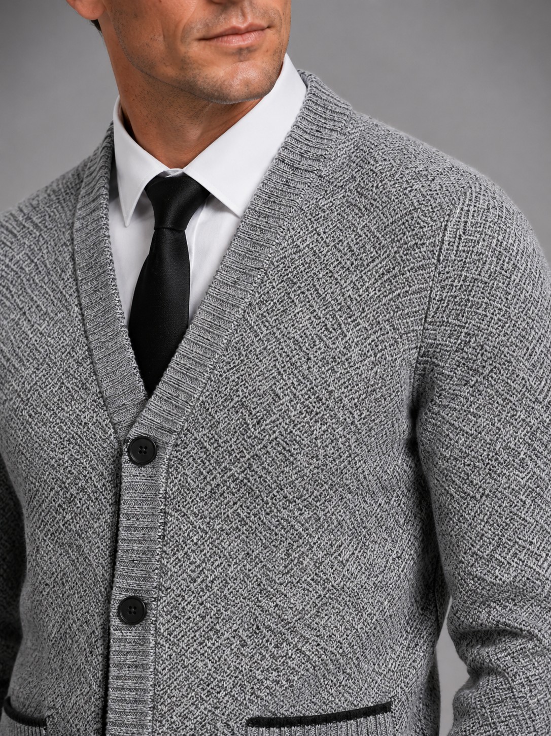 Close up of gray knit cardigan showing soft textured fabric and refined button front detail