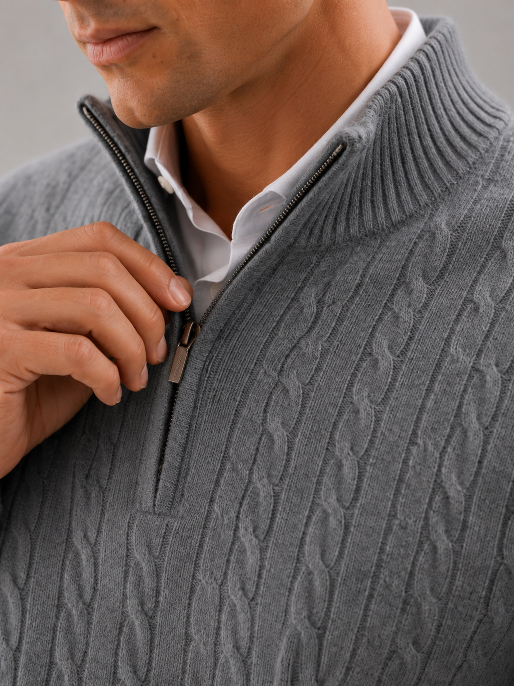 Close up of gray cashmere sweater showing soft cable knit texture and quarter zip detail