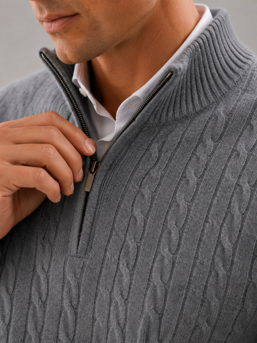 Close up of gray cashmere sweater showing soft cable knit texture and quarter zip detail