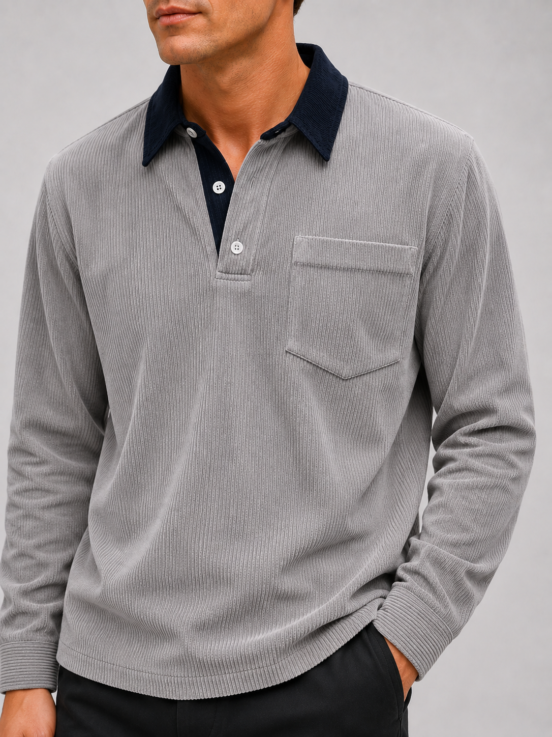 Close-up of a gray corduroy polo shirt showing the textured polyester fabric, contrast turn-down collar, button placket, cuffs, and stitching