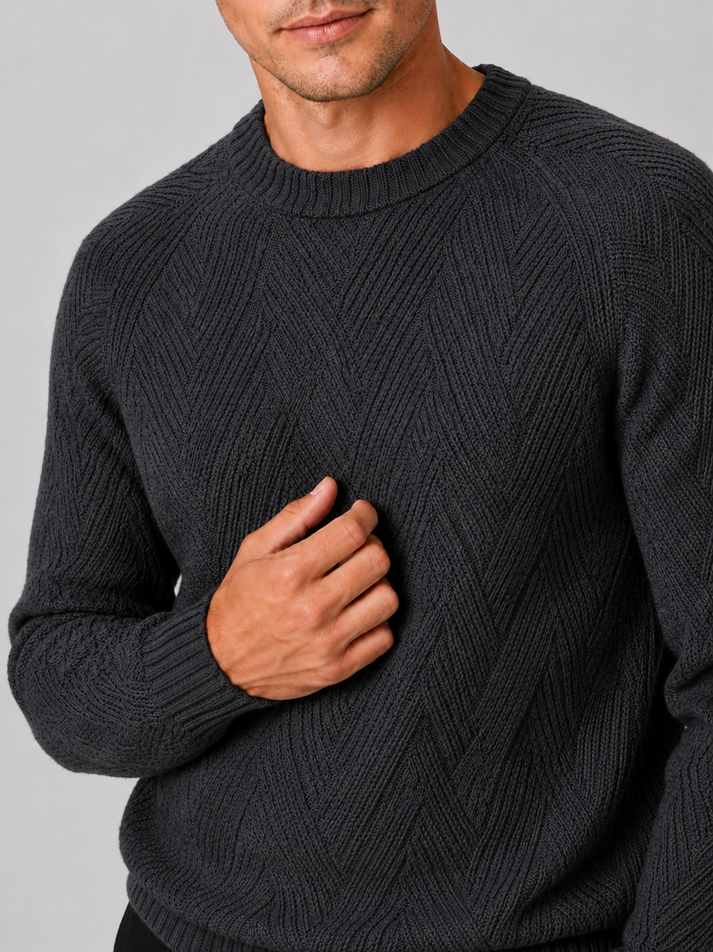 Close up of gray knit sweater showing soft textured fabric and classic crew neck detail