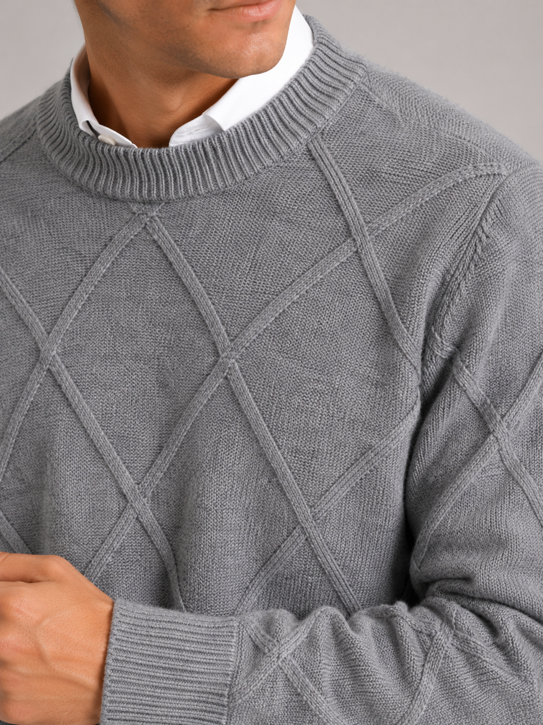 Close up of gray cable knit sweater showing soft fleece texture and thick woven detail
