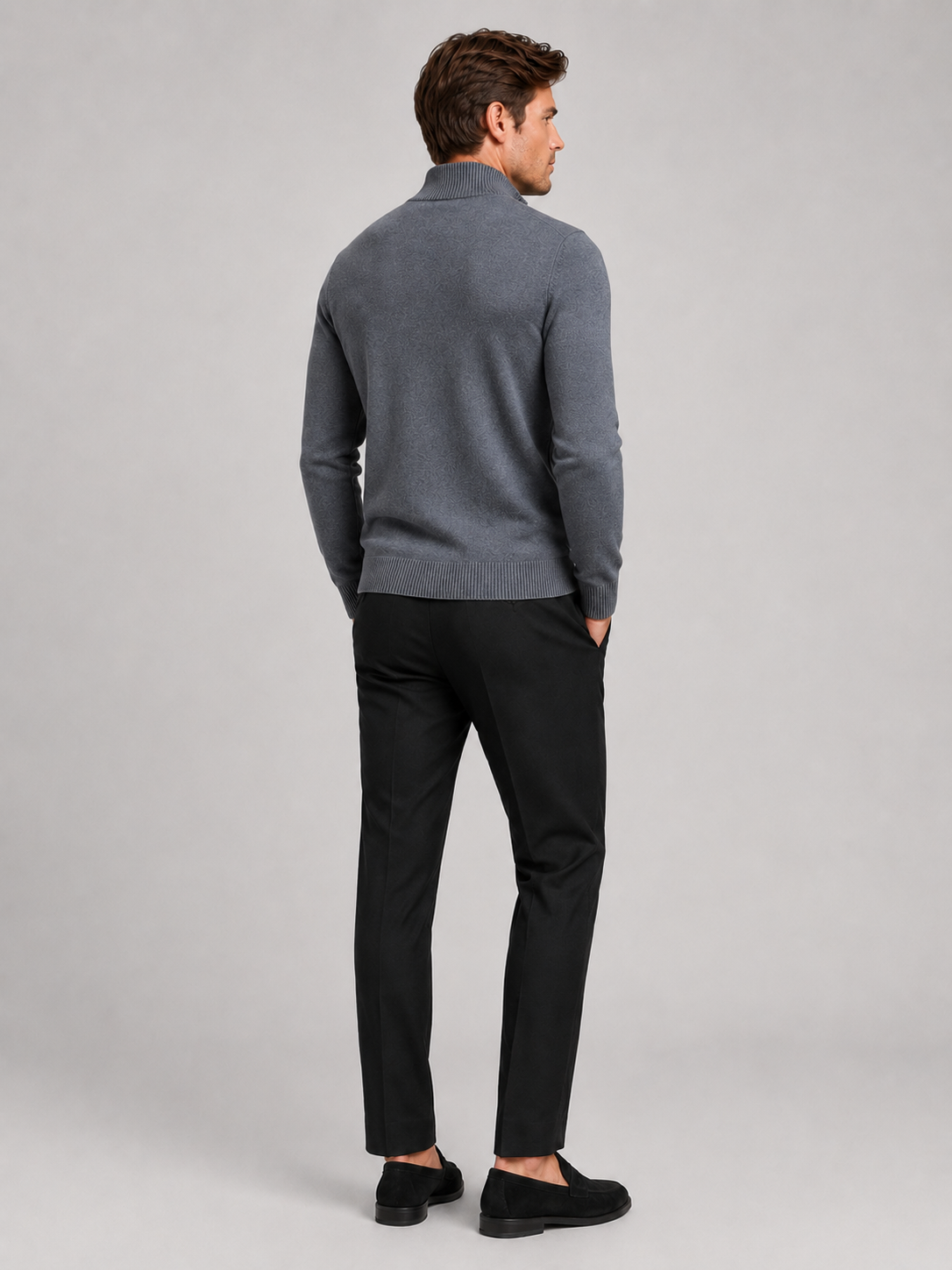 Back view of a man wearing a gray full zip knit sweater showing the slim fit, long sleeves, and clean knit construction