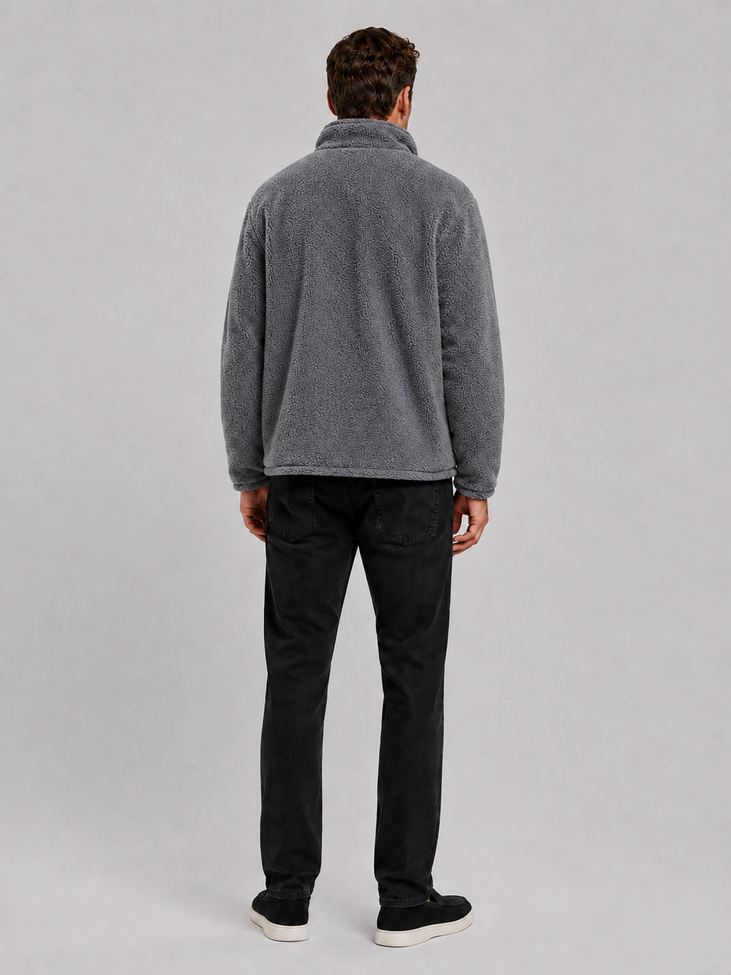 Back view of a man wearing a gray fleece jacket showing the relaxed loose fit, long sleeves, stand collar, and soft fleece construction